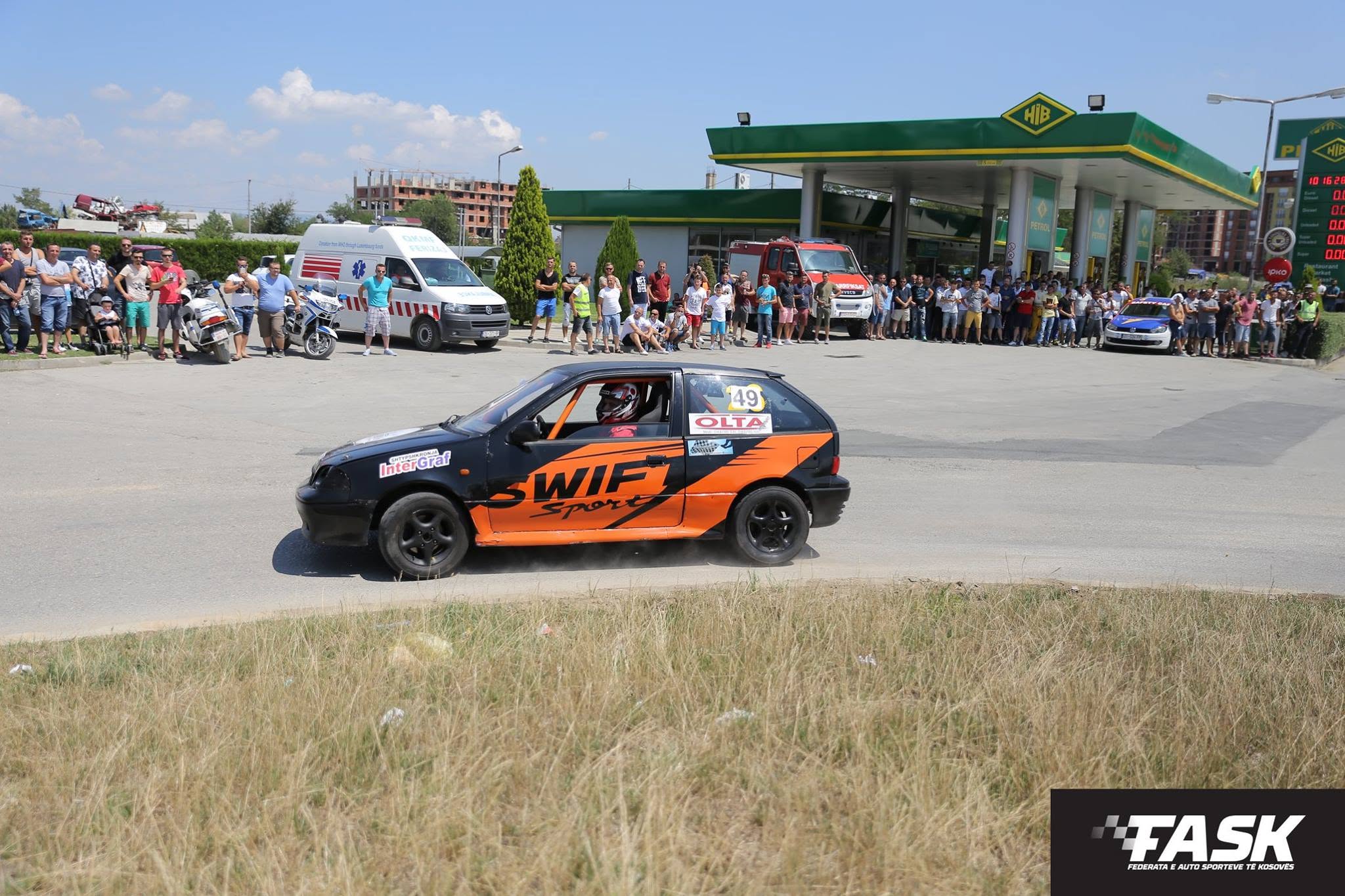 Veturë e zezë me portokalli në garën e auto sllallomit në Ferizaj, me publikun prapa